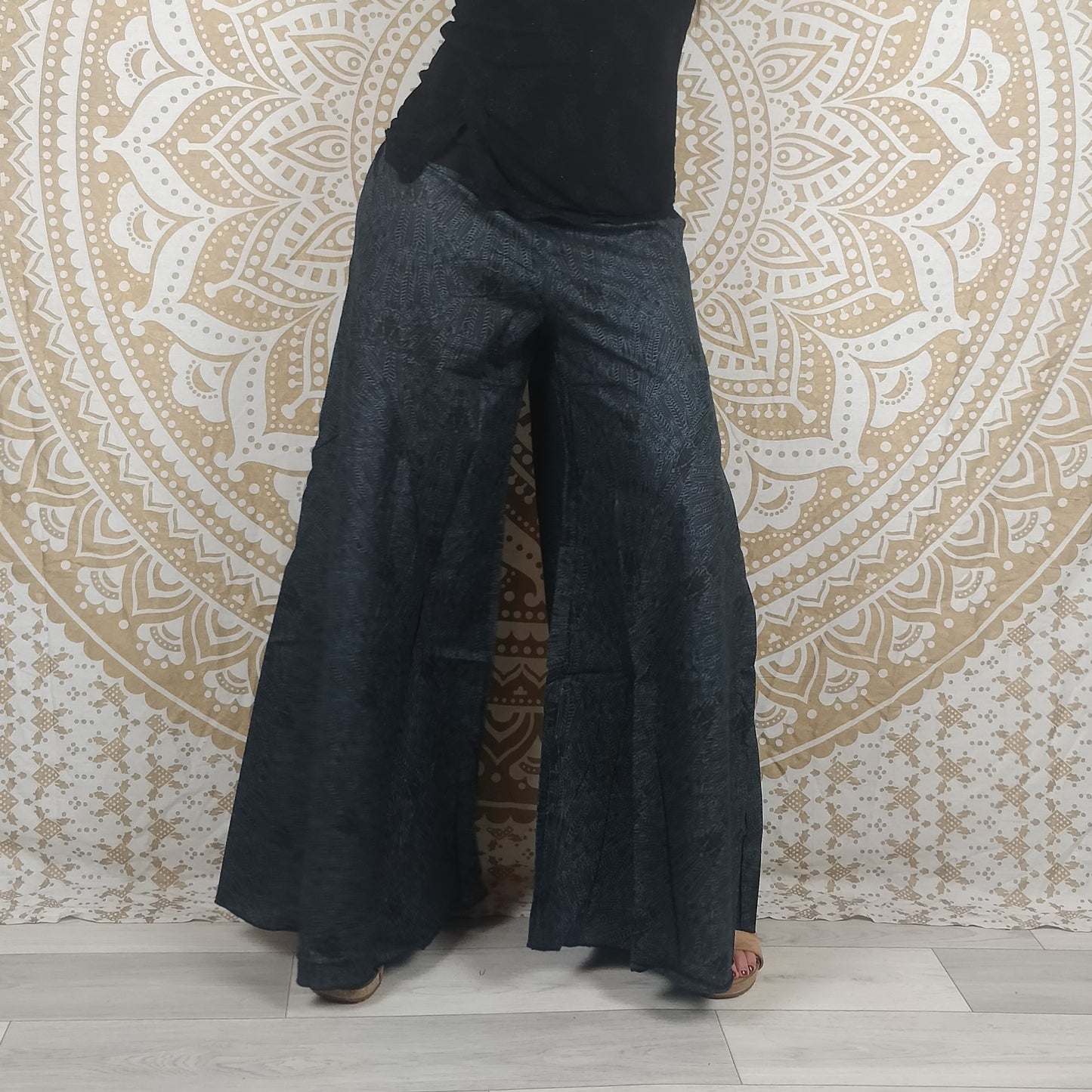 Pantalon Jebra en coton. Coupe ample et évasée, patte d'éléphant. Imprimé plumes grises foncées et noires.