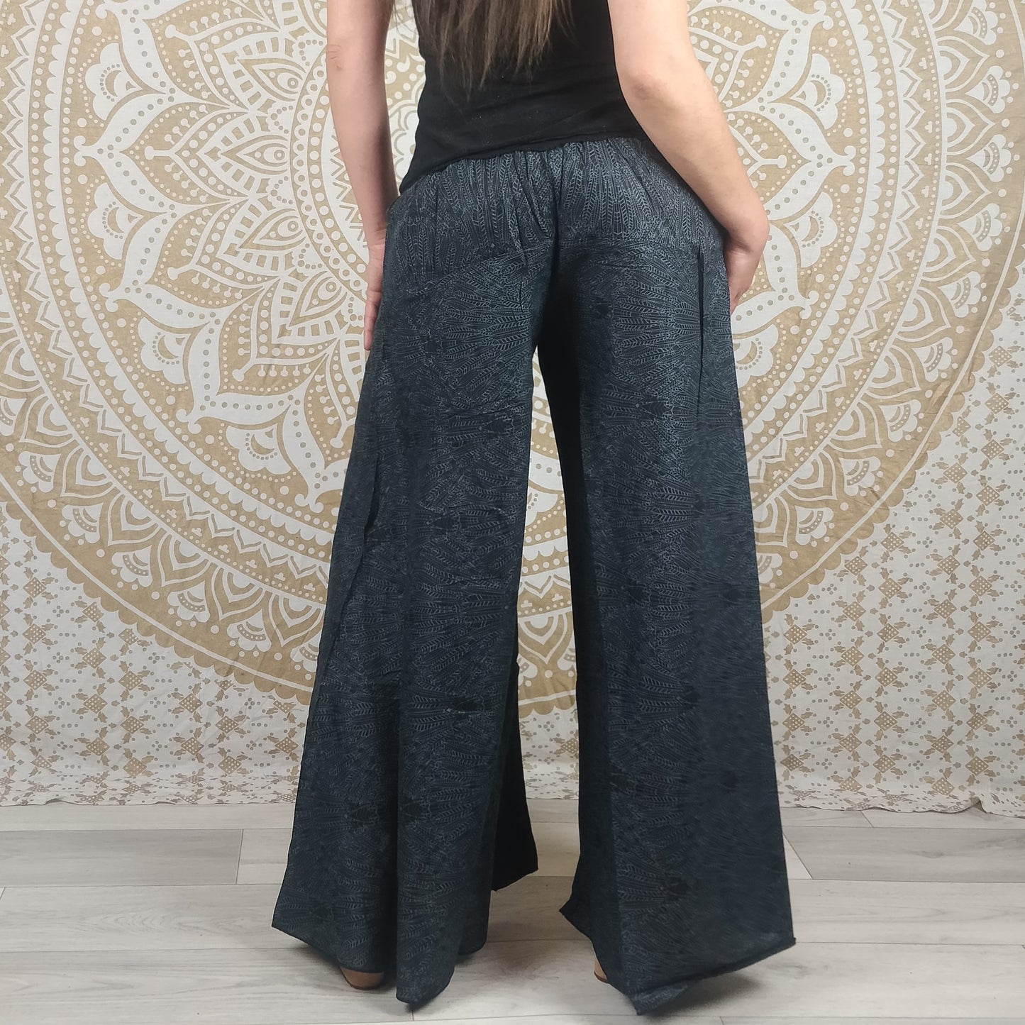 Pantalon Jebra en coton. Coupe ample et évasée, patte d'éléphant. Imprimé plumes grises foncées et noires.