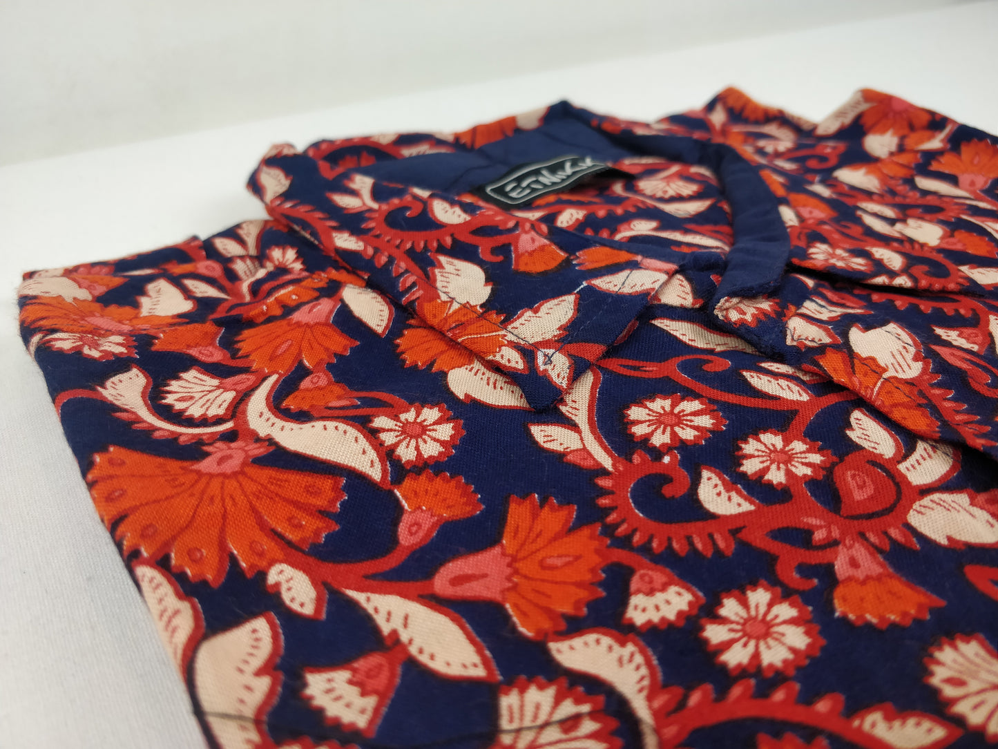 Chemise homme Ribhu manches courtes. Chemise décontractée souple en rayonne. Motif fleuri orange et bleu.