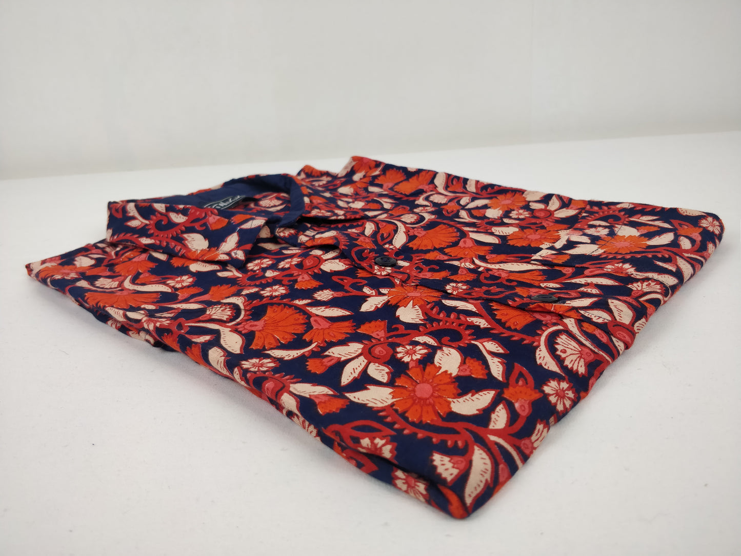 Chemise homme Ribhu manches courtes. Chemise décontractée souple en rayonne. Motif fleuri orange et bleu.