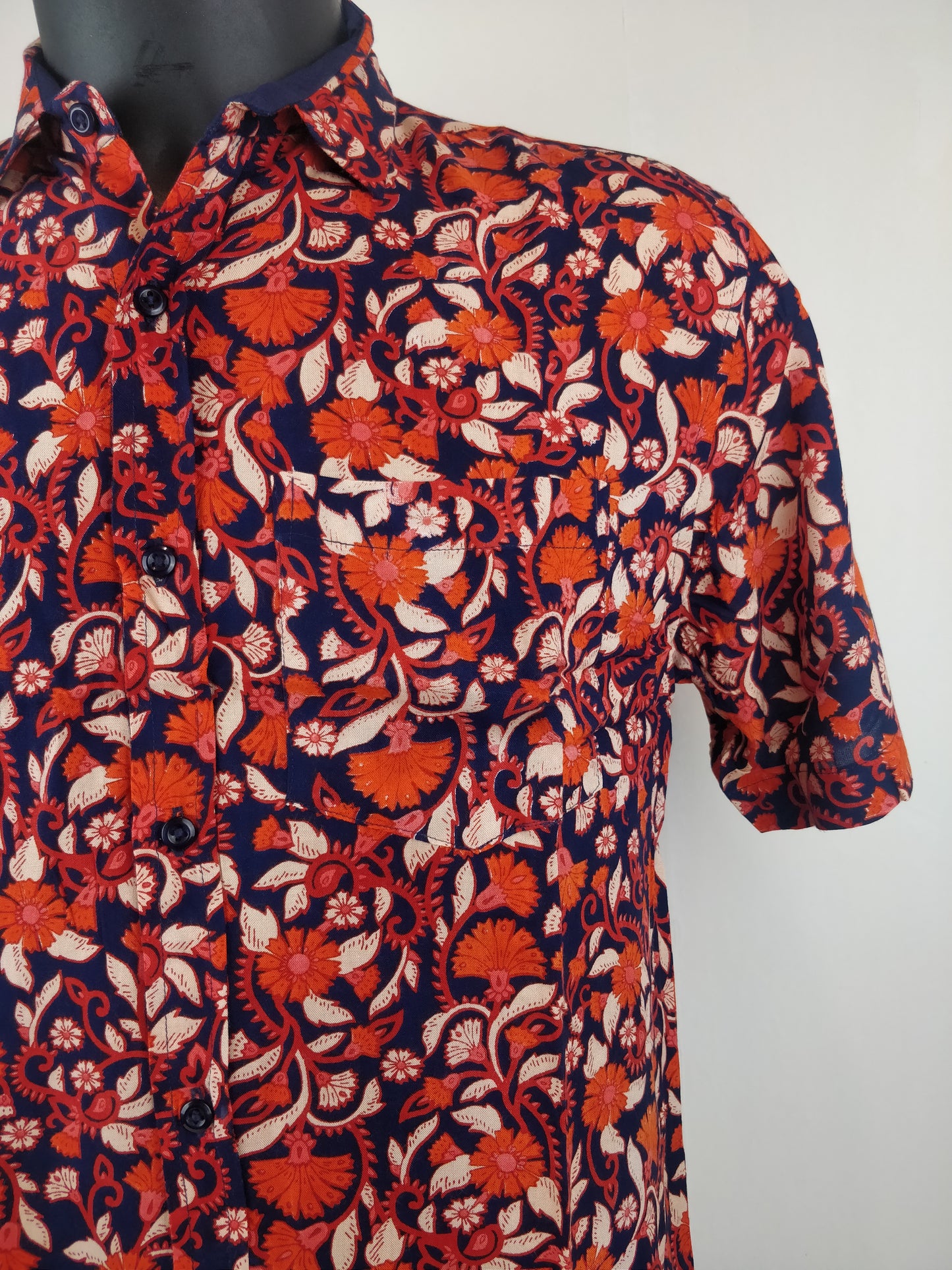 Chemise homme Ribhu manches courtes. Chemise décontractée souple en rayonne. Motif fleuri orange et bleu.