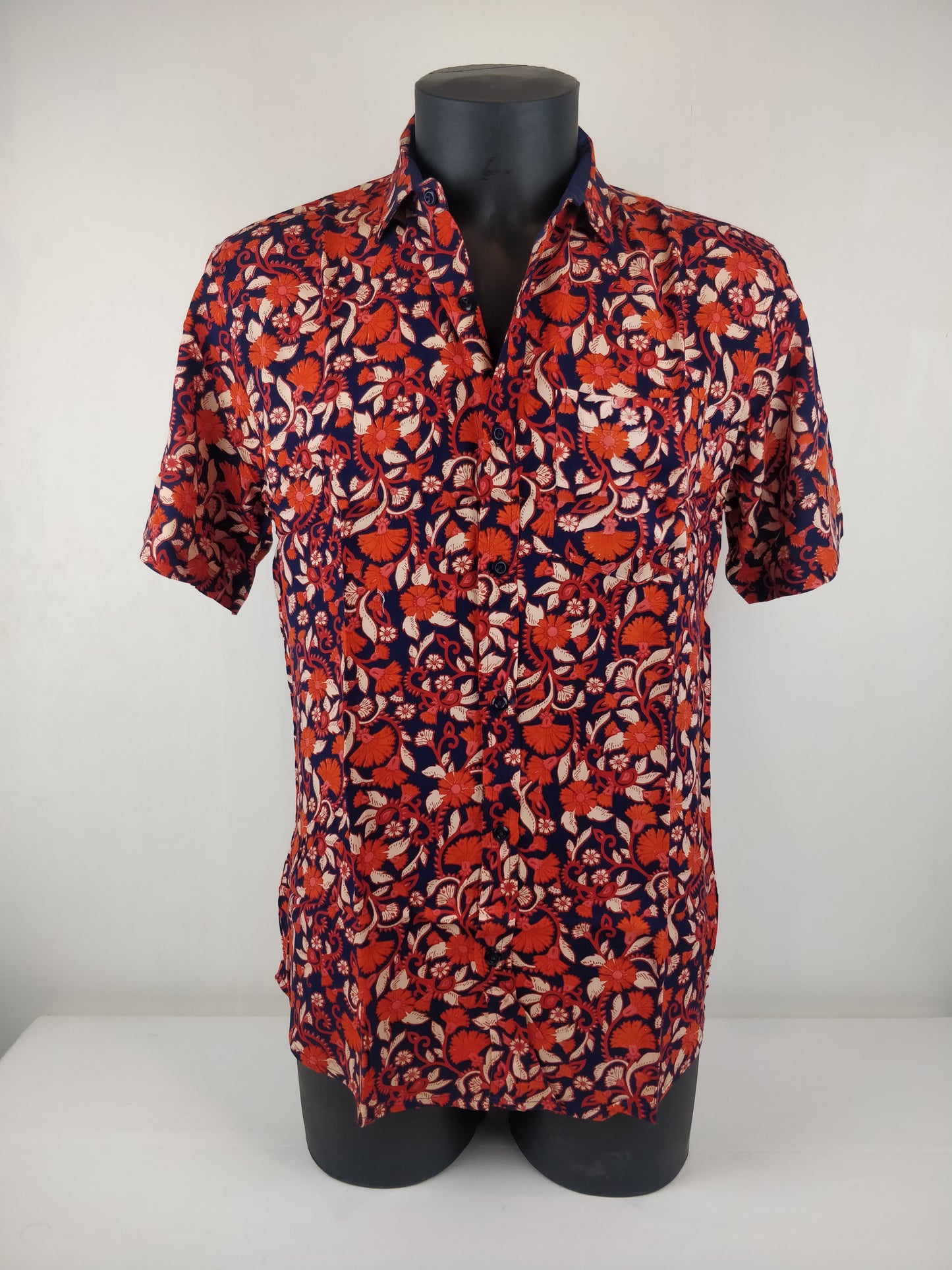 Chemise homme Ribhu manches courtes. Chemise décontractée souple en rayonne. Motif fleuri orange et bleu.