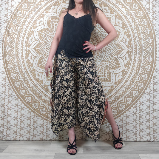 Pantalon femme Lubbha en soie indienne. Coupe évasé, fendu sur les côtés. Imprimé fleuri noir et blanc avec insertions or.