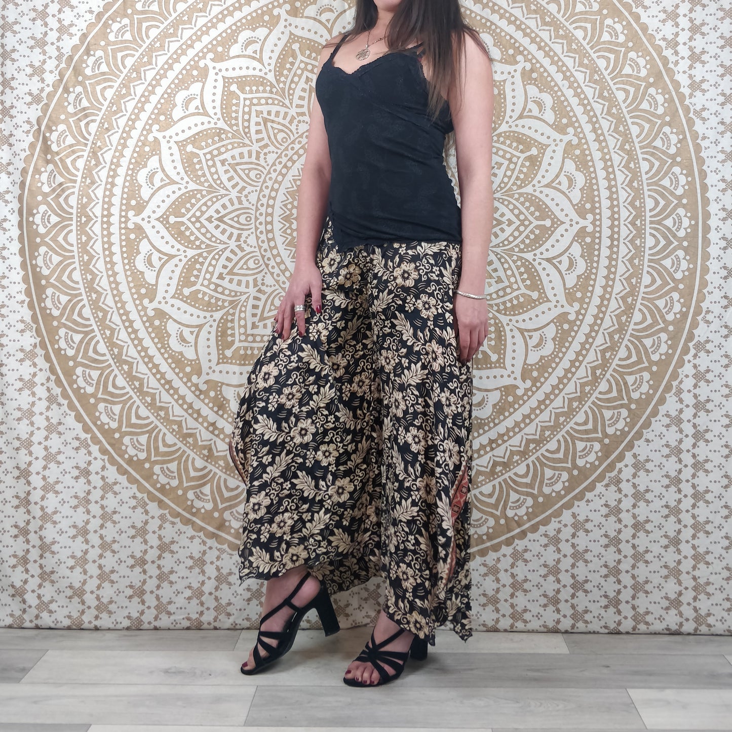 Pantalon femme Lubbha en soie indienne. Coupe évasé, fendu sur les côtés. Imprimé fleuri noir et blanc avec insertions or.