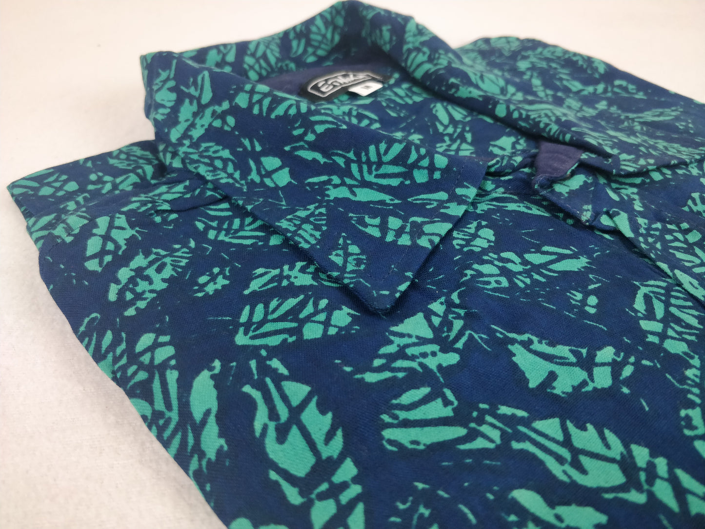 Chemise homme Ribhu manches courtes. Chemise décontractée souple en rayonne. Motif feuilles bleu et vert.