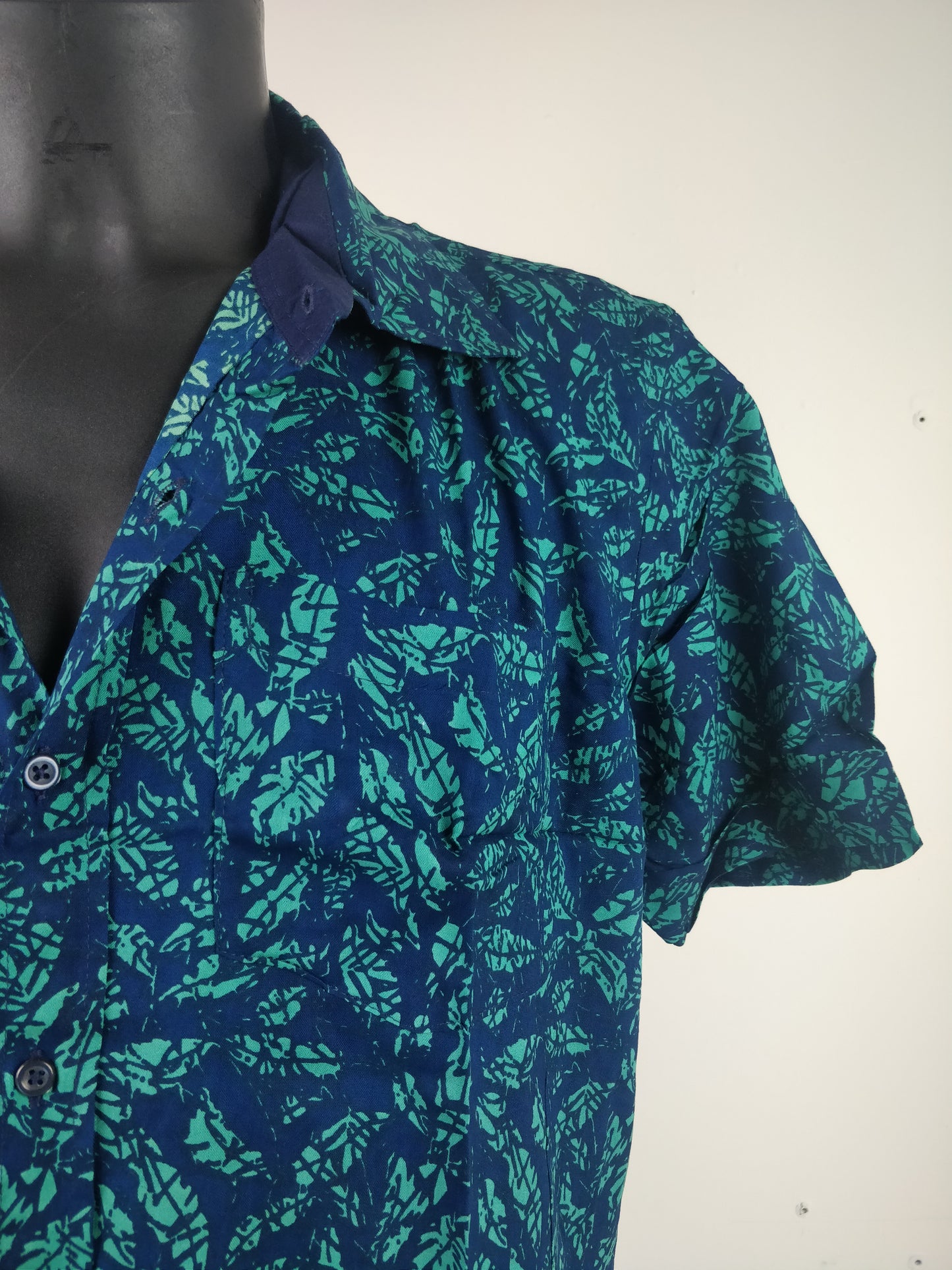 Chemise homme Ribhu manches courtes. Chemise décontractée souple en rayonne. Motif feuilles bleu et vert.