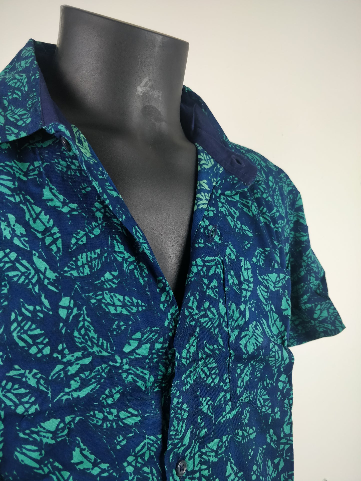 Chemise homme Ribhu manches courtes. Chemise décontractée souple en rayonne. Motif feuilles bleu et vert.