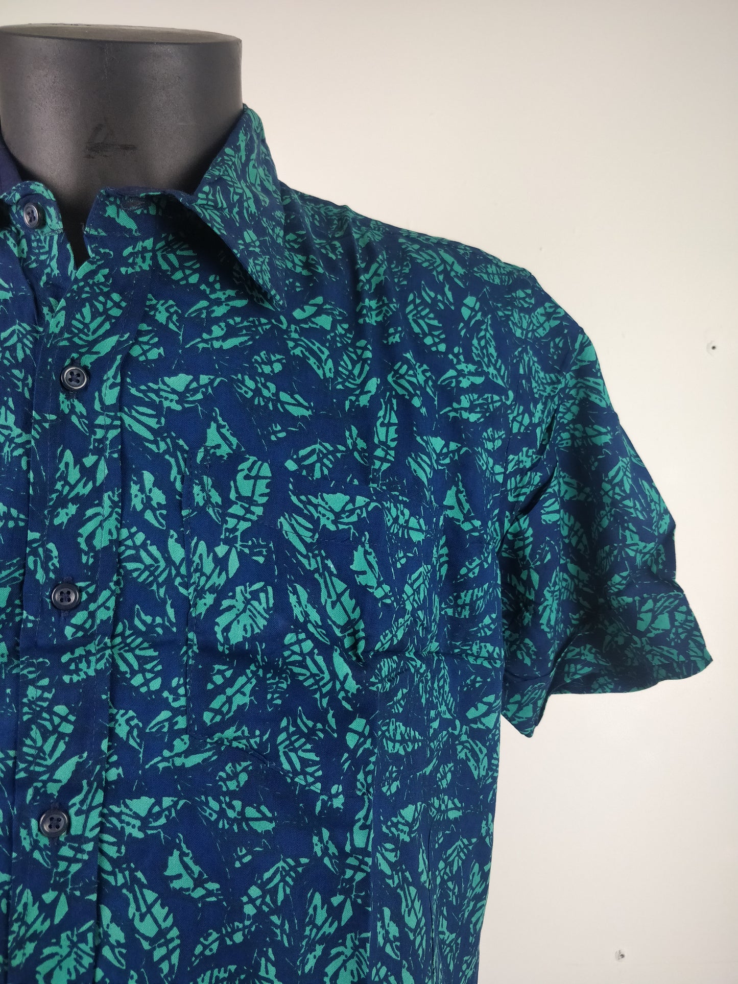 Chemise homme Ribhu manches courtes. Chemise décontractée souple en rayonne. Motif feuilles bleu et vert.