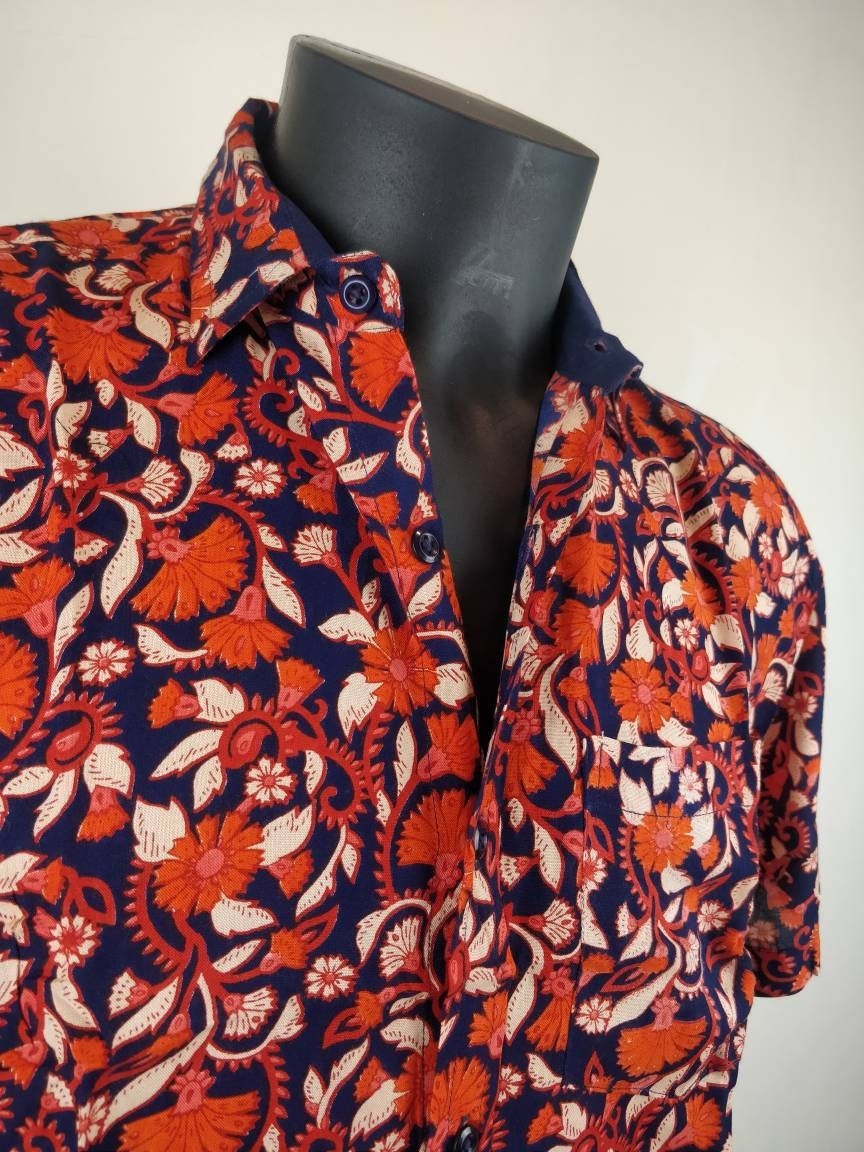 Chemise homme Ribhu manches courtes. Chemise décontractée souple en rayonne. Motif fleuri orange et bleu.