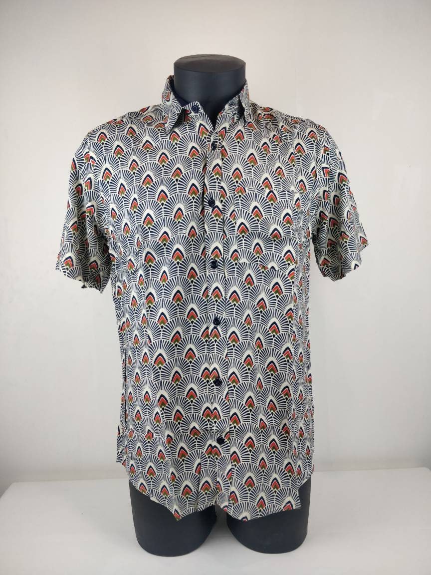 Chemise homme Ribhu manches courtes. Chemise décontractée souple en rayonne. Motifs géométriques blanc, bleu et orange.