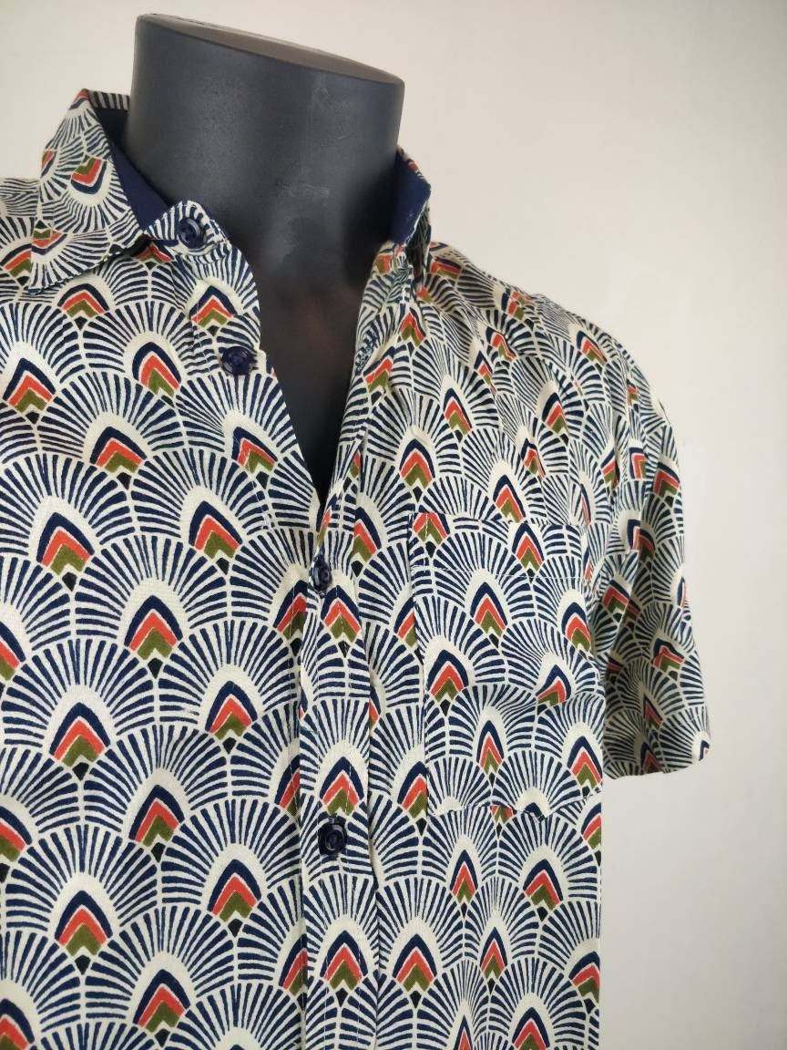 Chemise homme Ribhu manches courtes. Chemise décontractée souple en rayonne. Motifs géométriques blanc, bleu et orange.