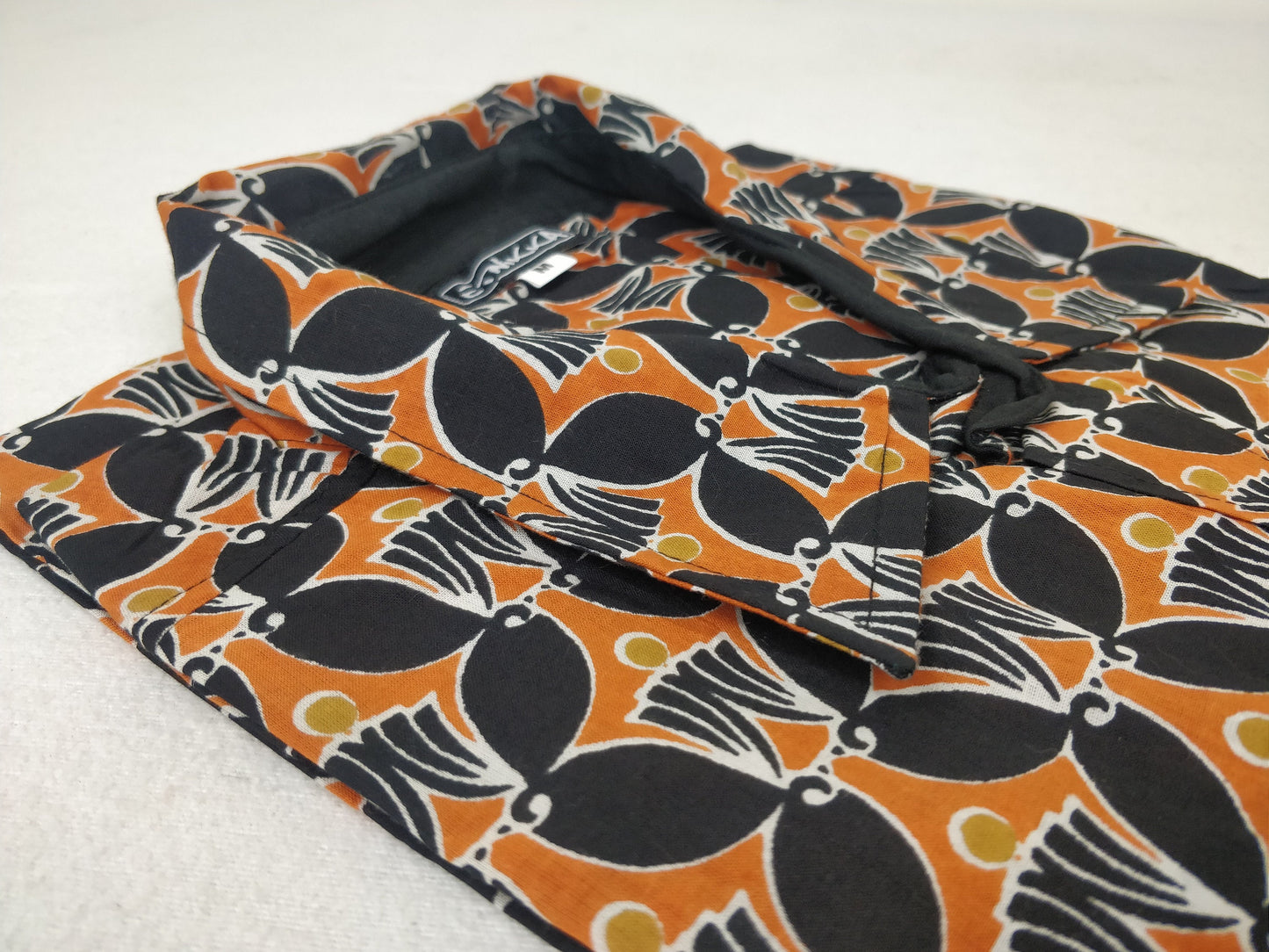 Chemise homme Ribhu manches courtes. Chemise en coton. Motifs ethnique orange et noir.