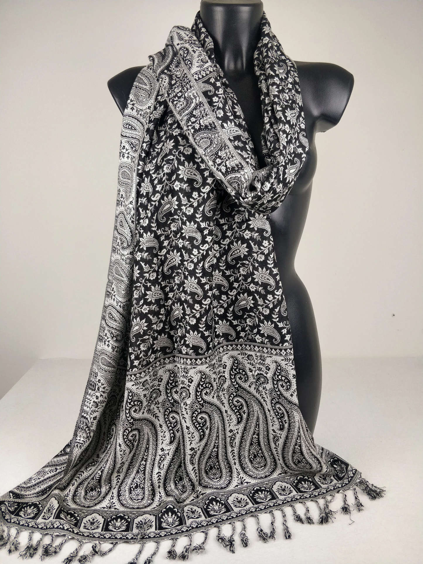 Écharpe pashmina réversible en viscose, ornée de motifs paisley noirs et blancs.